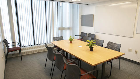 a reservable conference room, complete with table, chairs, and whiteboard