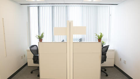 two open space workstations divided by a panel, complete with work desks, chairs, and computers