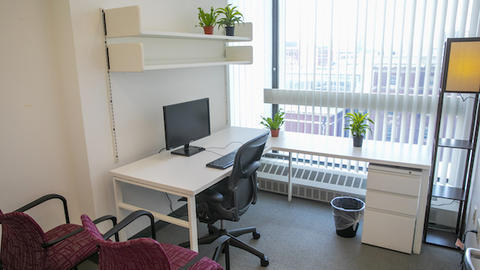 a sunny private workspace complete with work desk, computer, chairs, and basic amenities