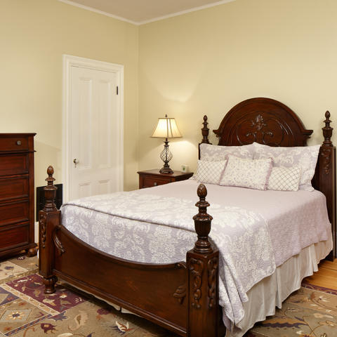 Bedroom with full sized bed, hard flooring, and a dresser in view