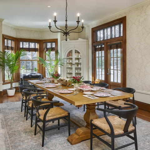 Formal dining room with room for hosting, long table with multiple chairs and large windows overlooking the greenery