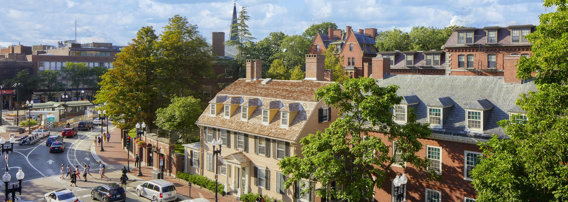 Overhead view of the Harvard Square area, facing the Wadsworth House entrance to Harvard Yard, with bustling activity from cars and pedestrians