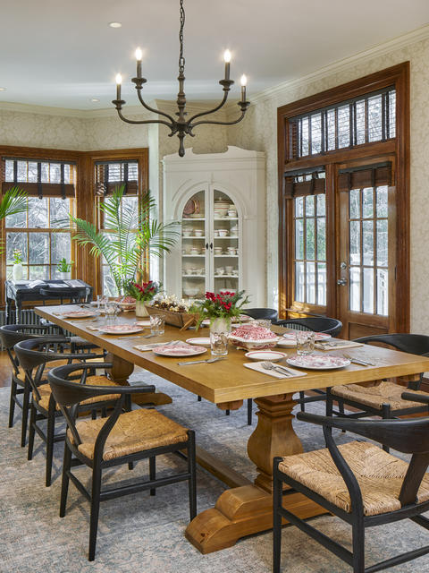 Formal dining room with room for hosting, long table with multiple chairs and large windows overlooking the greenery